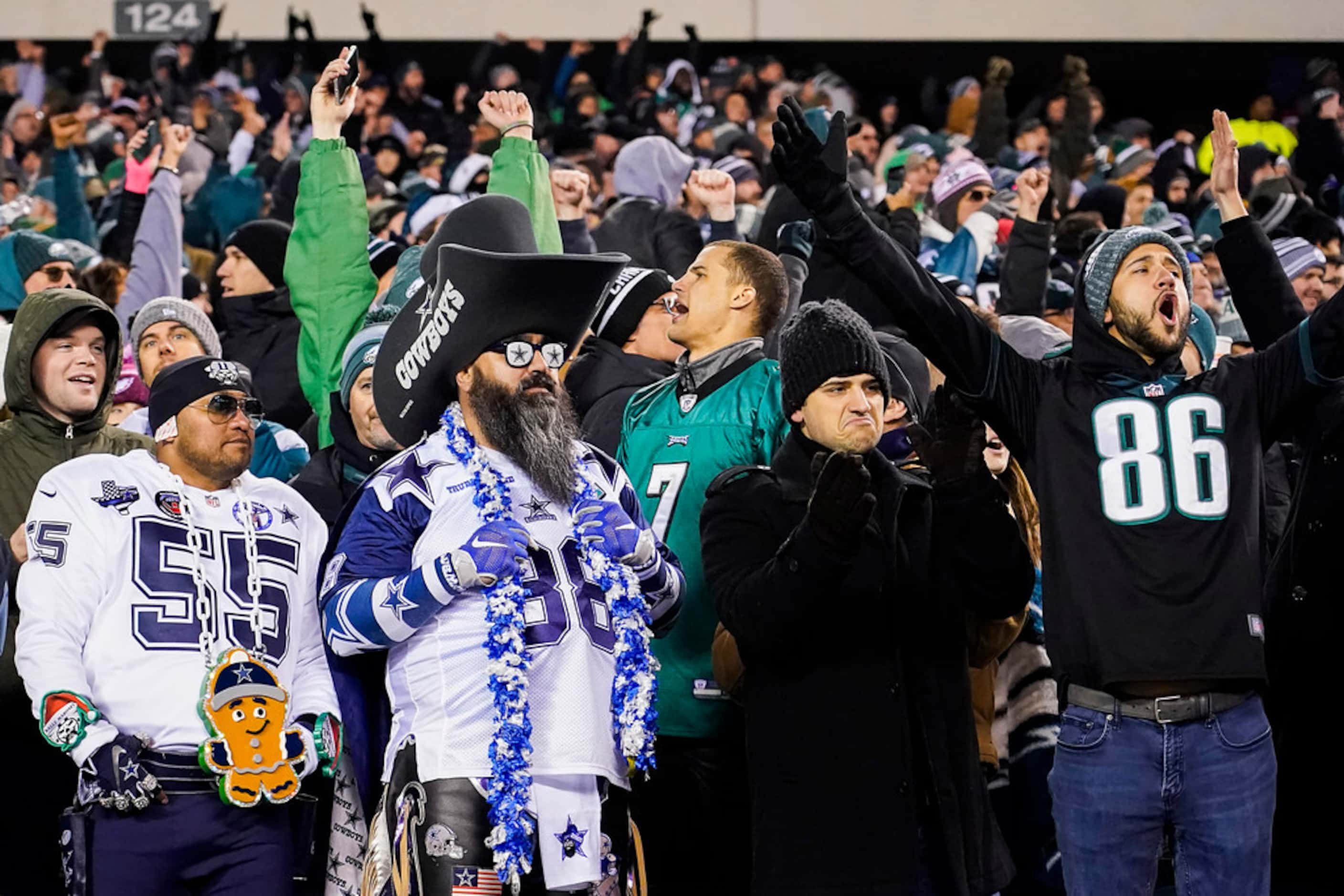 Philadelphia Eagles fans celebrate as two Dallas Cowboys fans look on in silence after a...