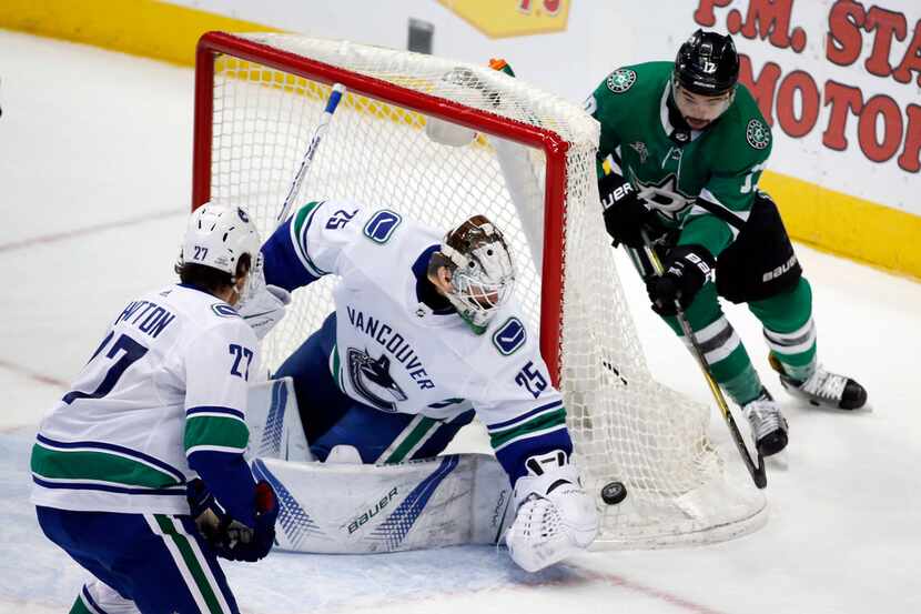 Vancouver Canucks goaltender Jacob Markstrom (25) gets to the puck before Dallas Stars...