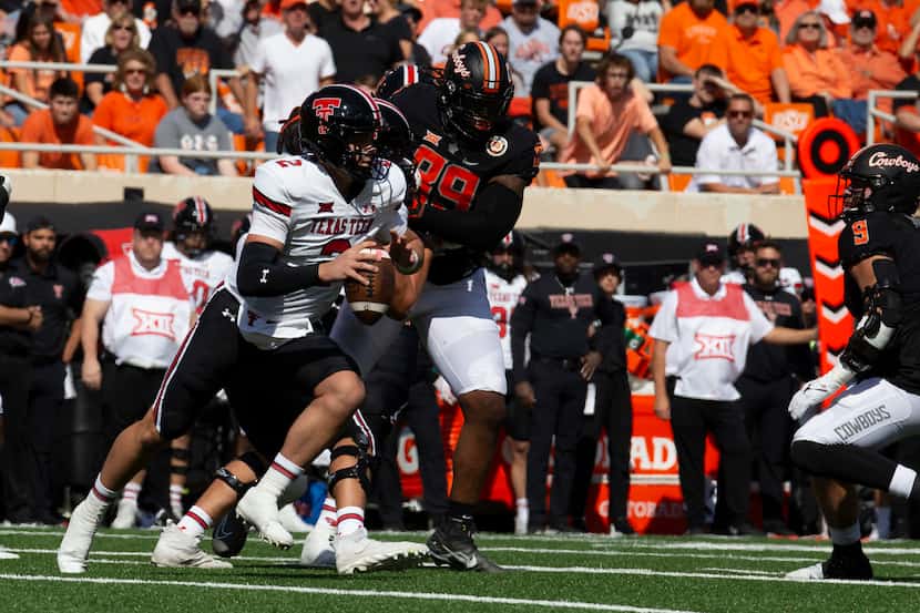 Texas Tech's quarterback Behren Morton (2) is chased by Oklahoma State's Tyler Lacy (89)...