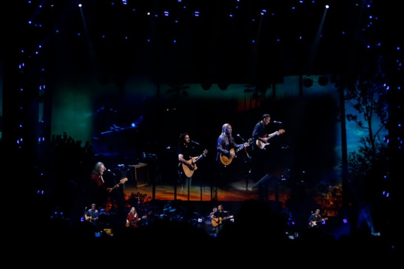 Members of the iconic band the Eagles are accompanied by larger than life images projected...