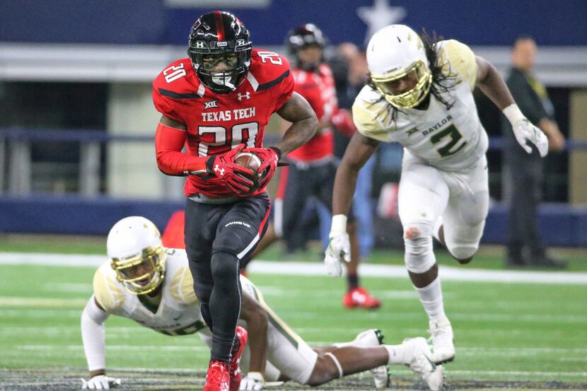 Texas Tech Red Raiders wide receiver Keke Coutee (20) eludes two Baylor defenders on his way...