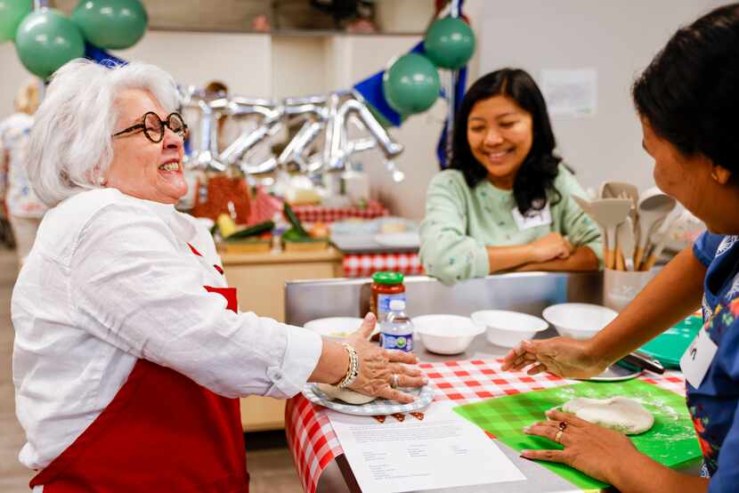Terri Heard (left) jokes with women in the cooking class she teaches at HHM Health in Dallas. 