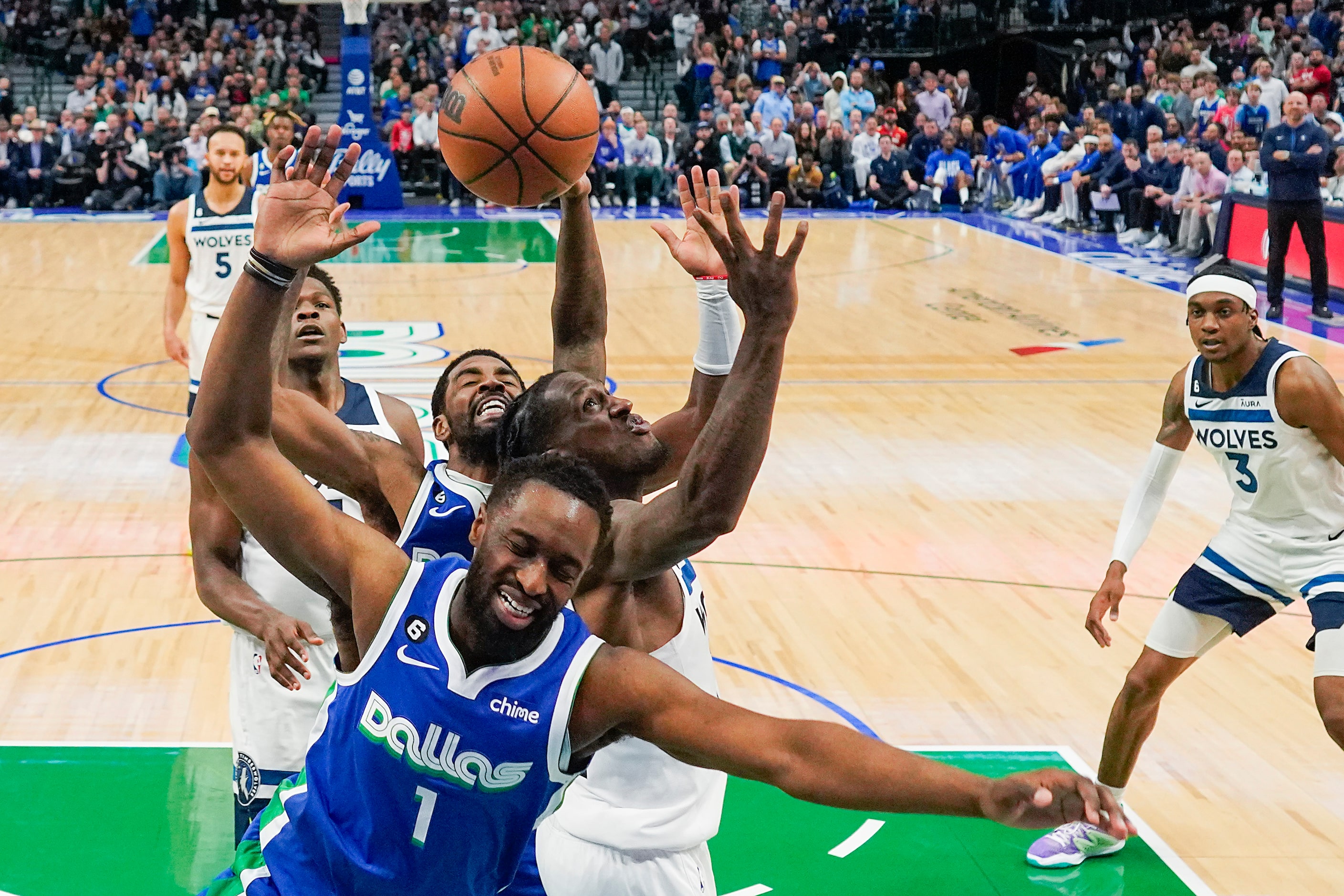 Dallas Mavericks guard Theo Pinson (1) and guard Kyrie Irving (middle) fight for a rebound...