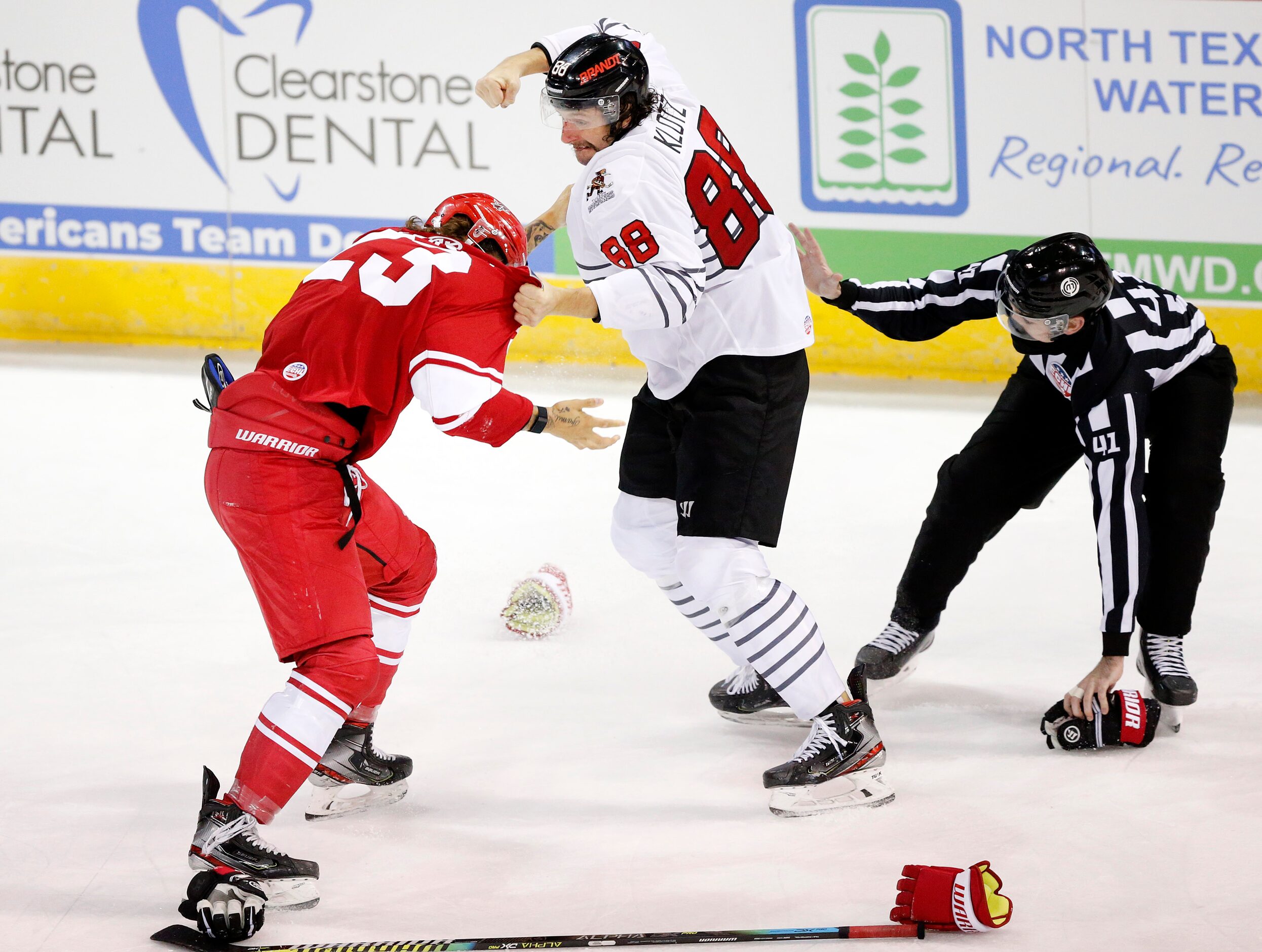 Allen Americans defenseman Cole Fraser (23) and Rapid City Rush forward Garrett Klotz duke...