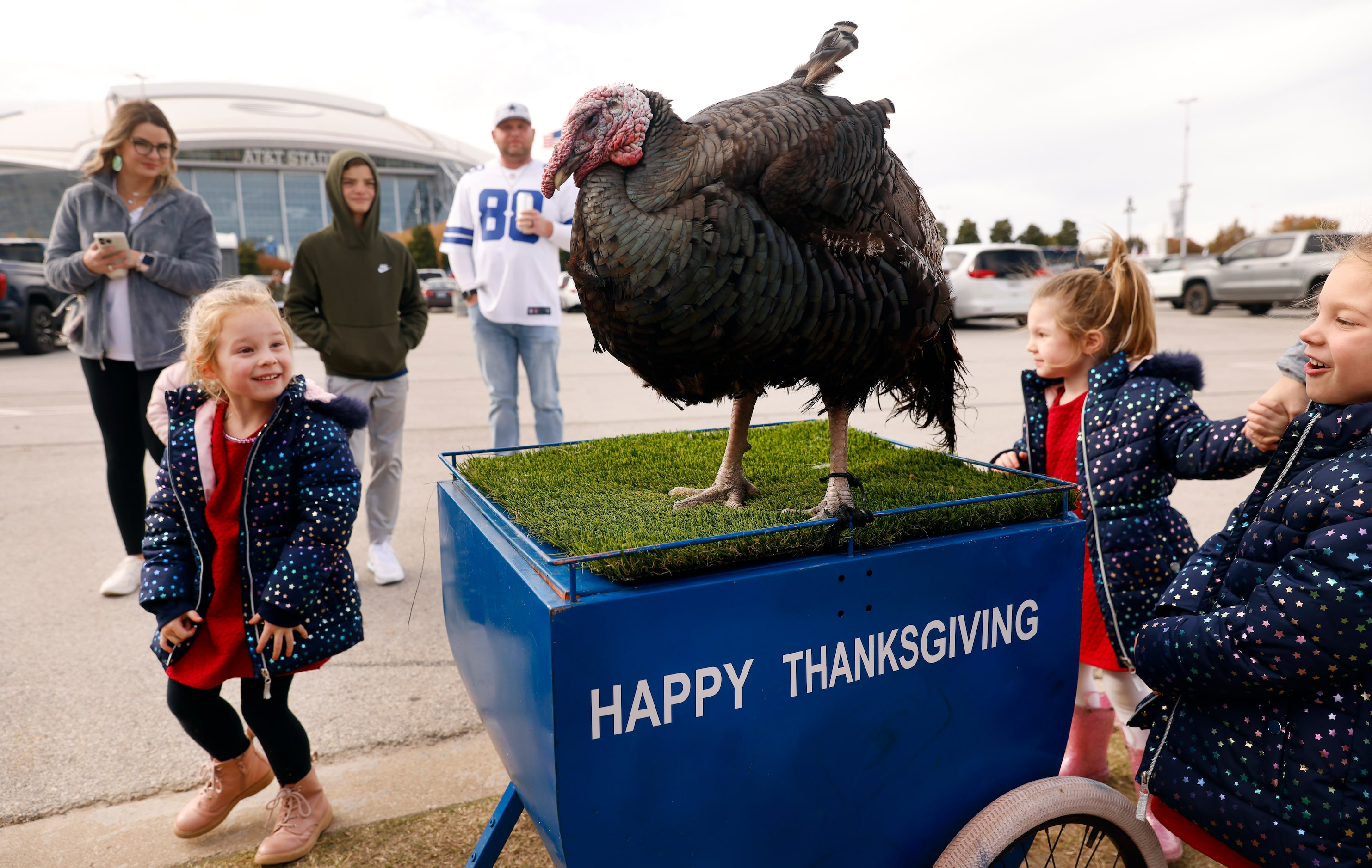 Decker Welanetz of Plano (left) is scared to pet Tailgate Tom the turkey wither sisters at a...