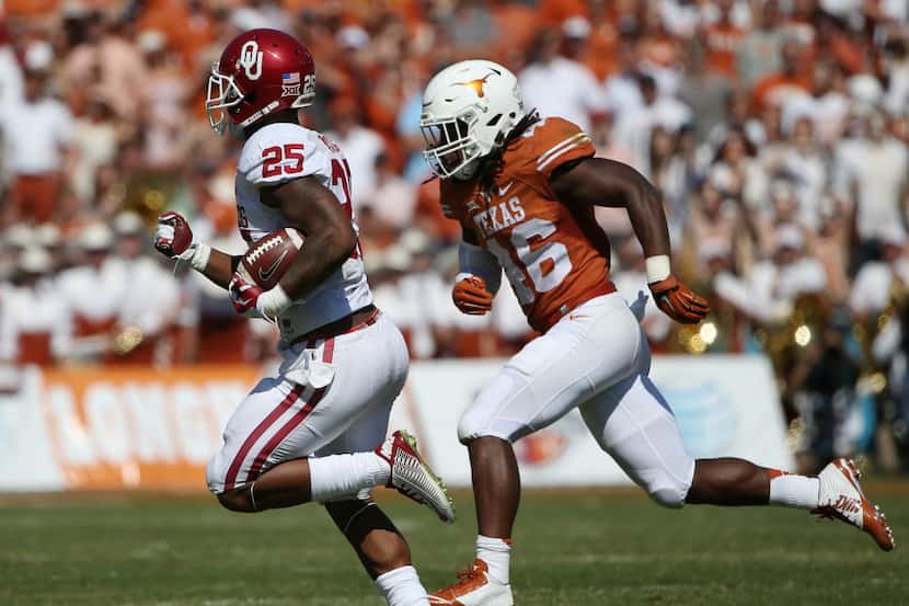 Oklahoma Sooners running back Joe Mixon (25) rushes the ball while being defended by Texas...