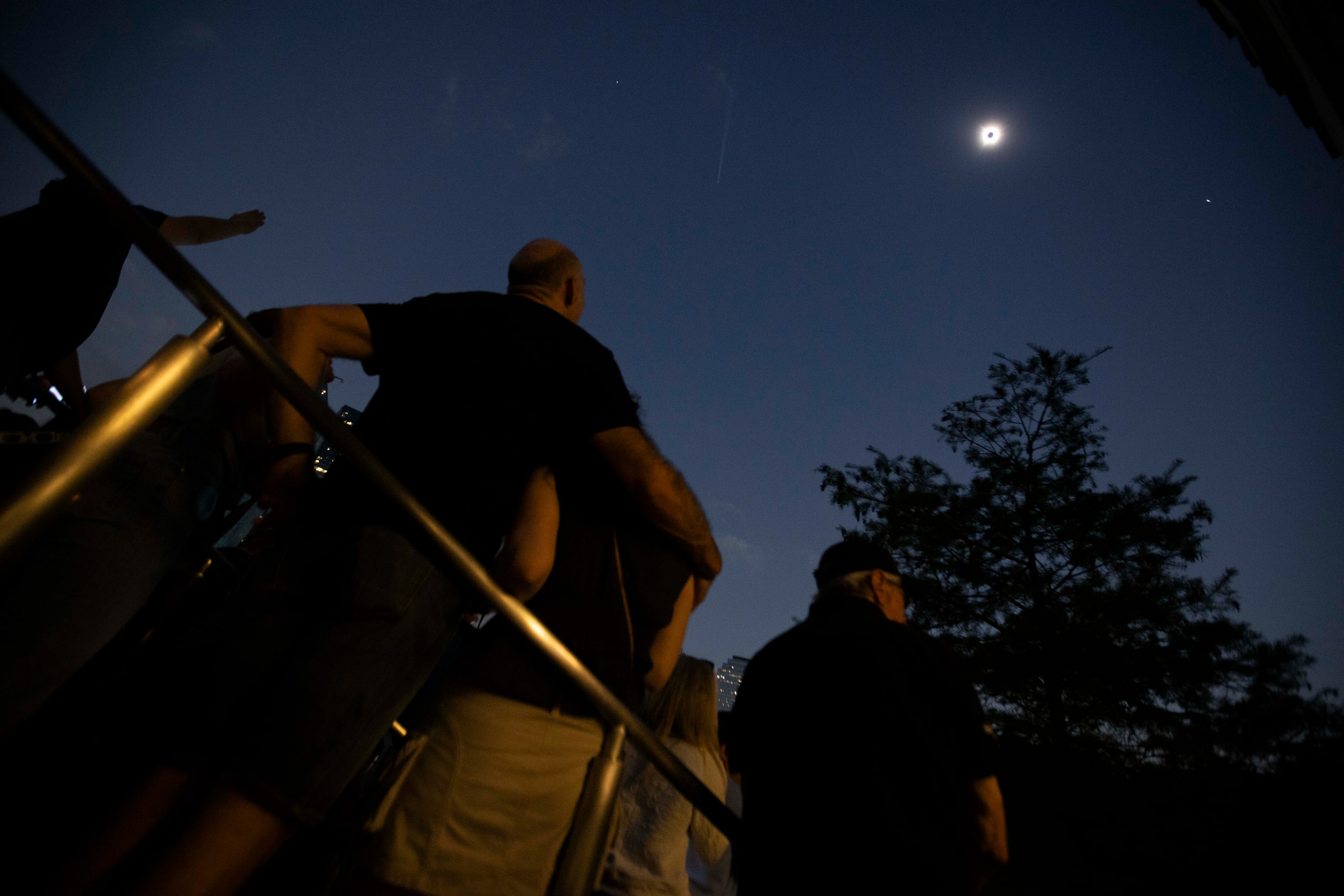 People watch the total eclipse during the Great North American Eclipse event at the Perot...