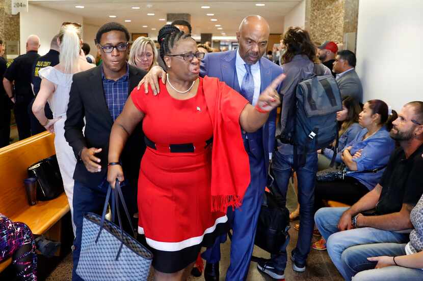 Botham Jean's mother, Allison Jean (center), leaves the 204th District Court after fired...