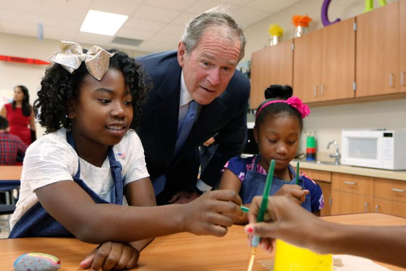 Former President George W. Bush visited with K-4 students Kendall Williams (left) and Eden...