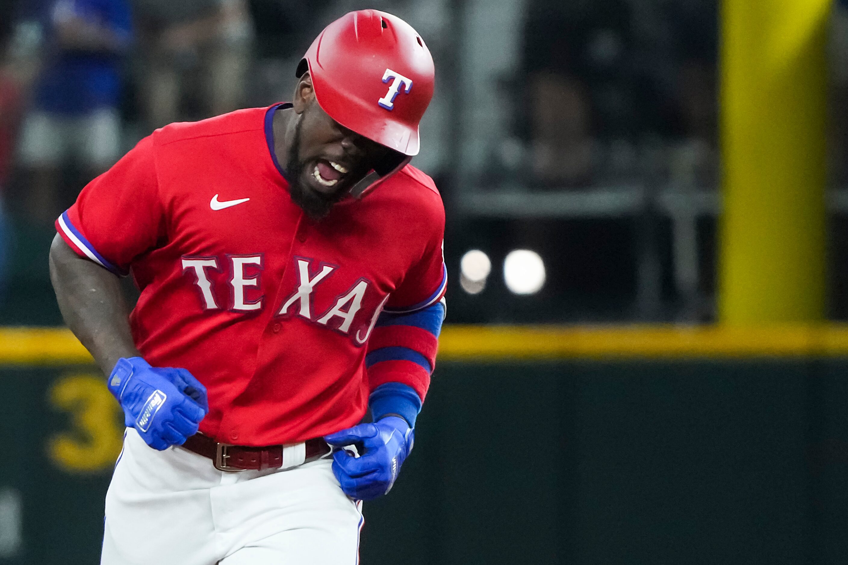 Texas Rangers center fielder Adolis Garcia celebrates as he rounds the bases after hitting a...