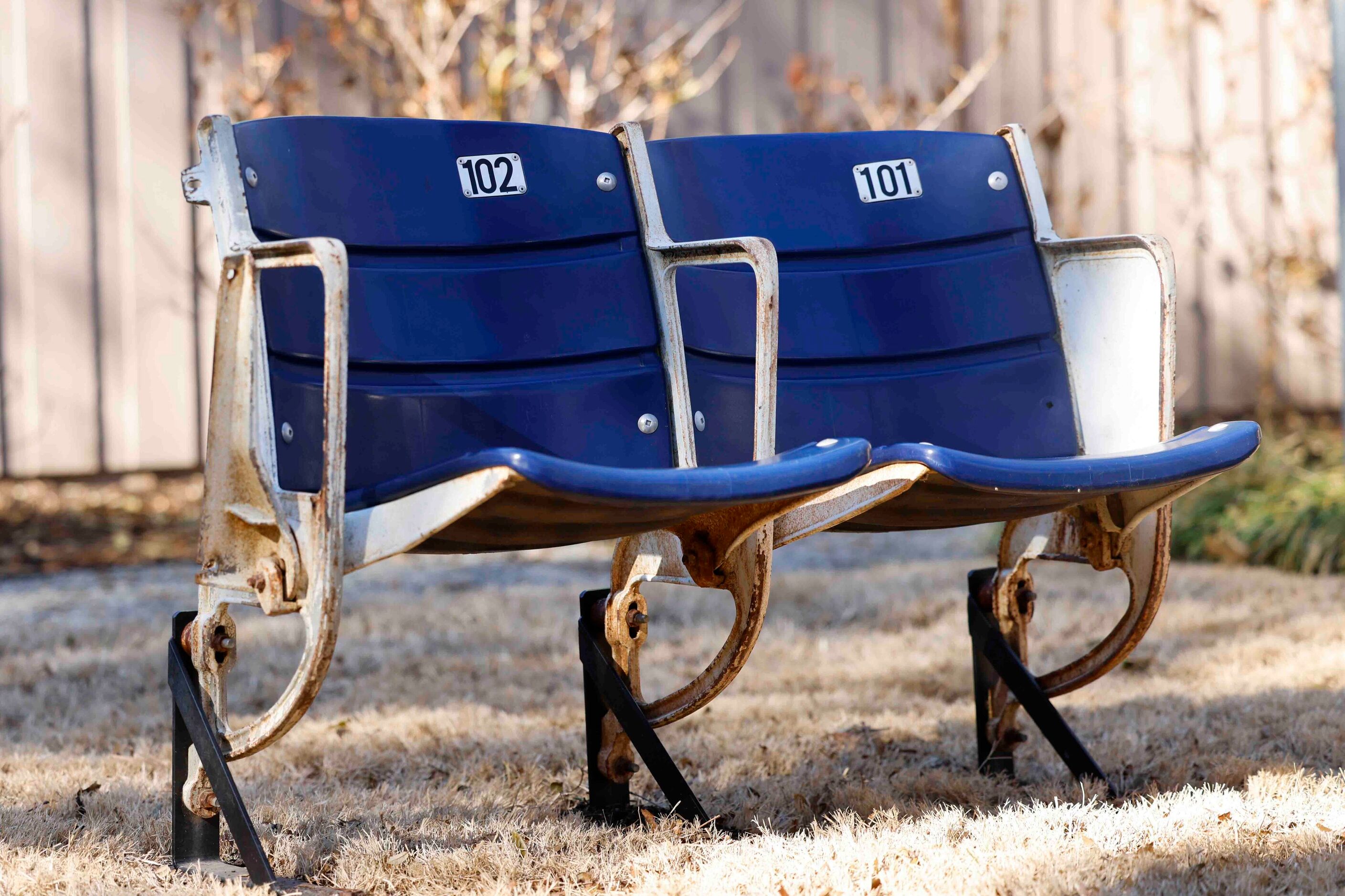 Seats from the old Cowboys stadium belonging to fans Marc and Miles Andres sit on the lawn...