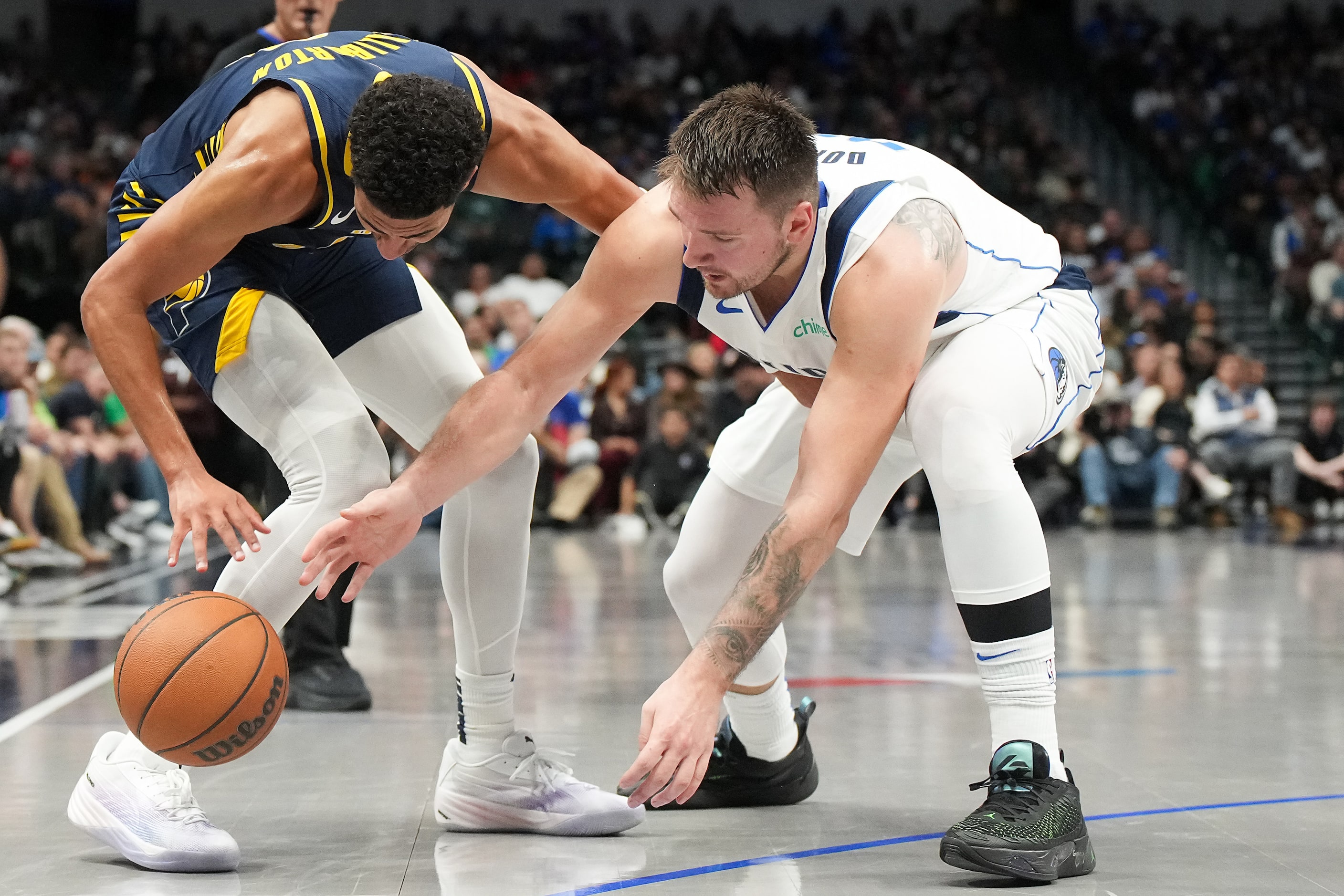 Dallas Mavericks guard Luka Doncic (77) flights for a loose ball with Indiana Pacers guard...