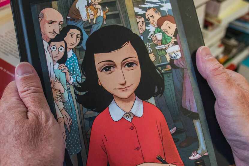 A man holds a copy of the graphic novel version of "The Diary of Anne Frank", by Israeli...