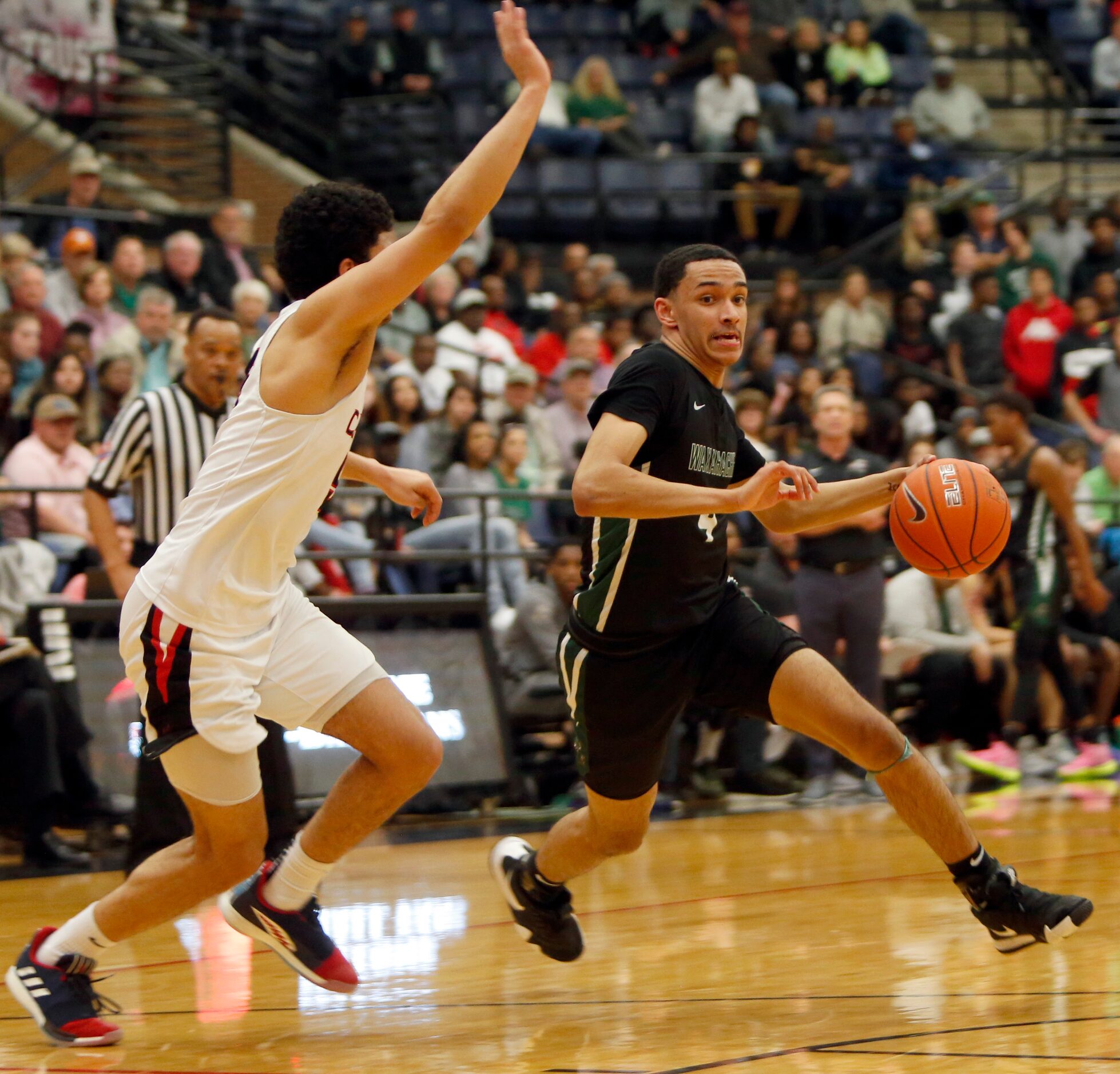 Waxahachie guard Jalen Lake (4) breaks for the basket as Coppell guard Adam Moussa (5)...