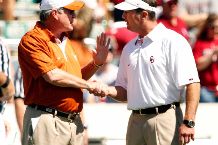 Texas head coach Mack Brown (left) talks with Oklahoma head coach Bob Stoops before their...