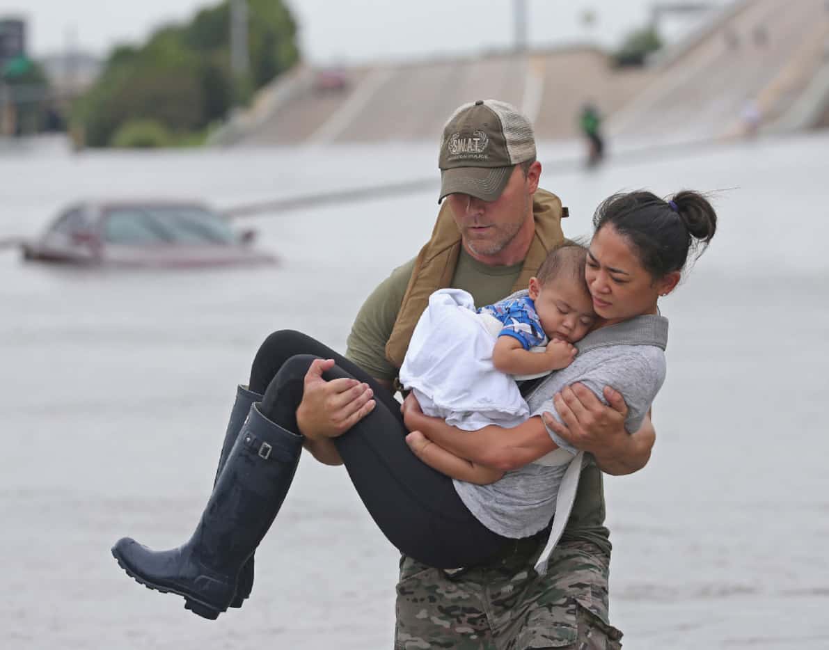 Houston SWAT officer Daryl Hudeck carries Catherine Pham and her son 13-month-old son Aiden...