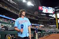 Rhett Miller walks on the field to sing the national anthem before a baseball game between...