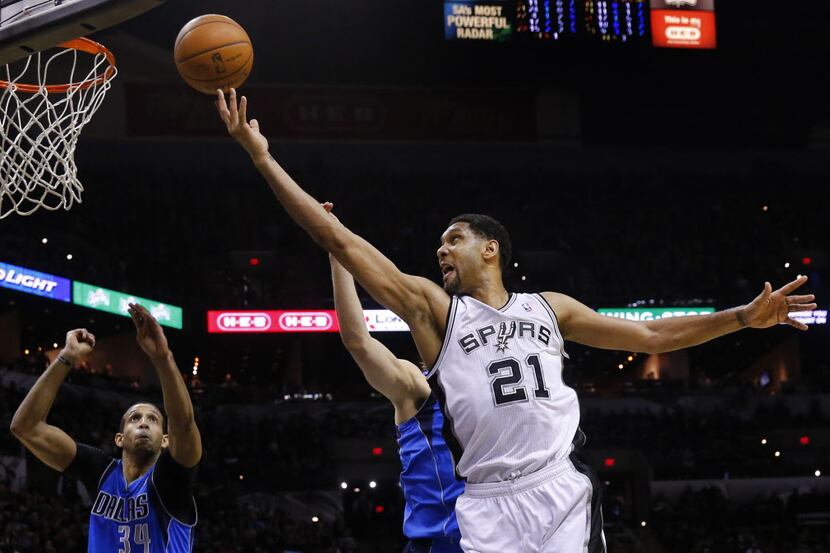 San Antonio Spurs forward Tim Duncan (21) lays up[ a shot past Dallas Mavericks forward Dirk...