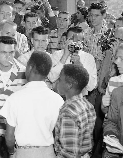 Defiant white students at Arkansas' North Little Rock High School block the doors of the...