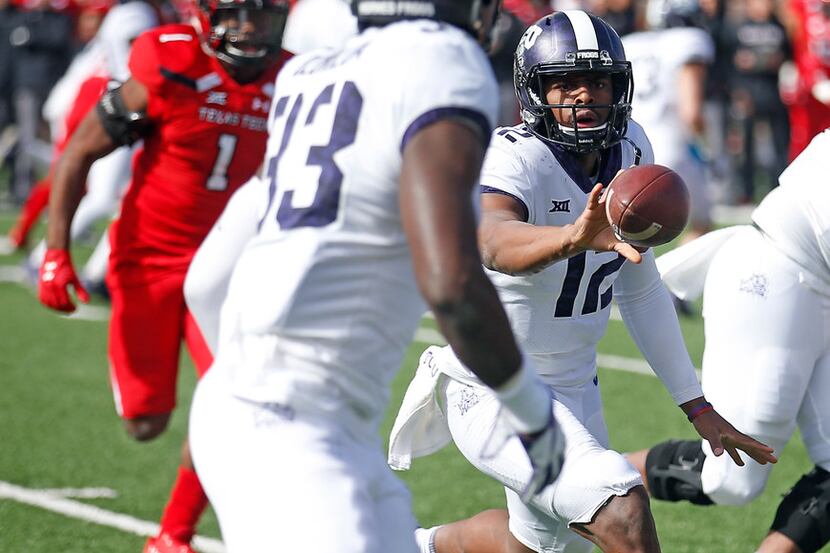 TCU's Shawn Robinson (12) pitches the ball to Sewo Olonilua (33) during the first half of...