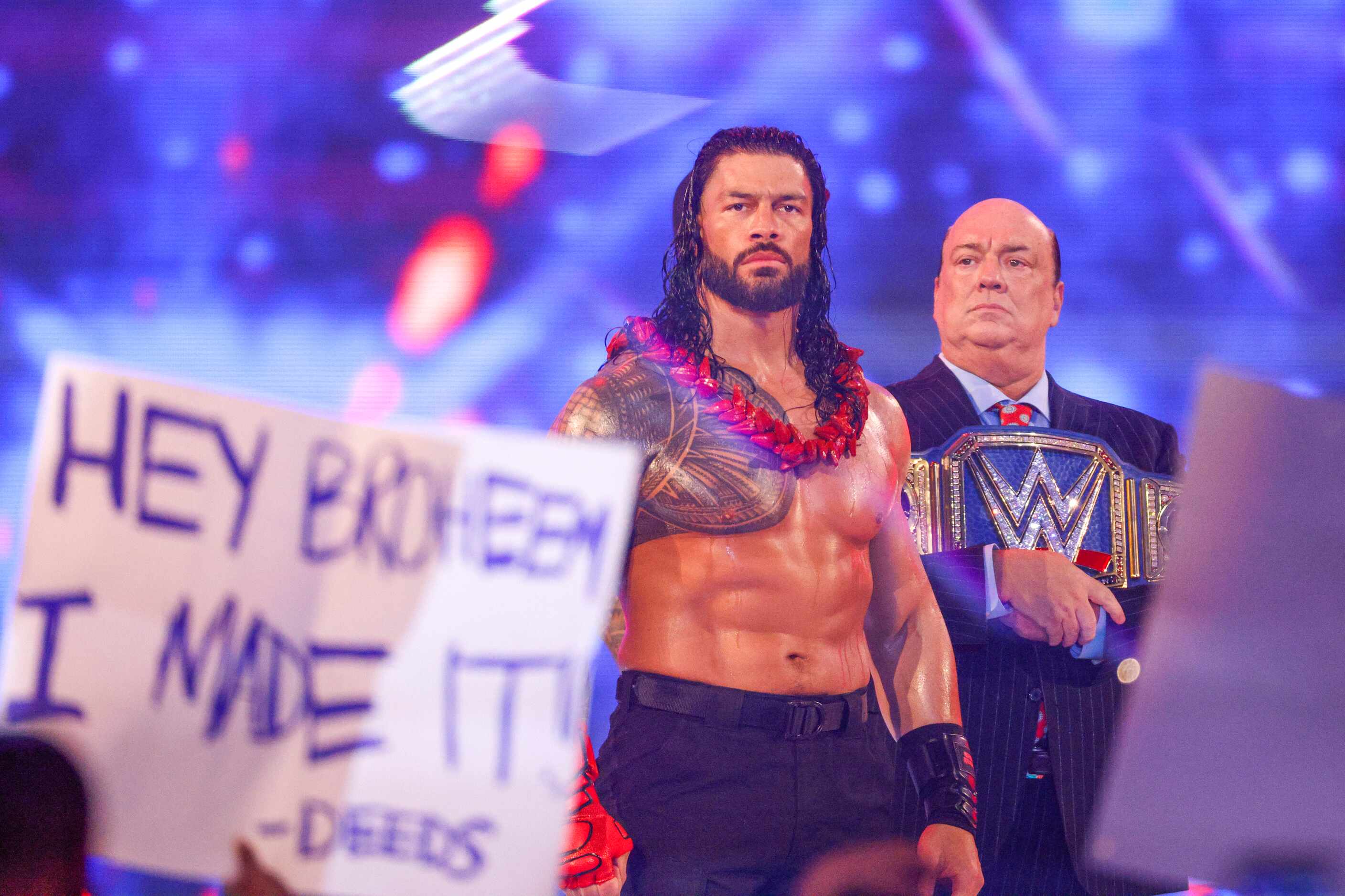 Roman Reigns (left) walks to the ring as Paul Heyman carries his belt before a match at...