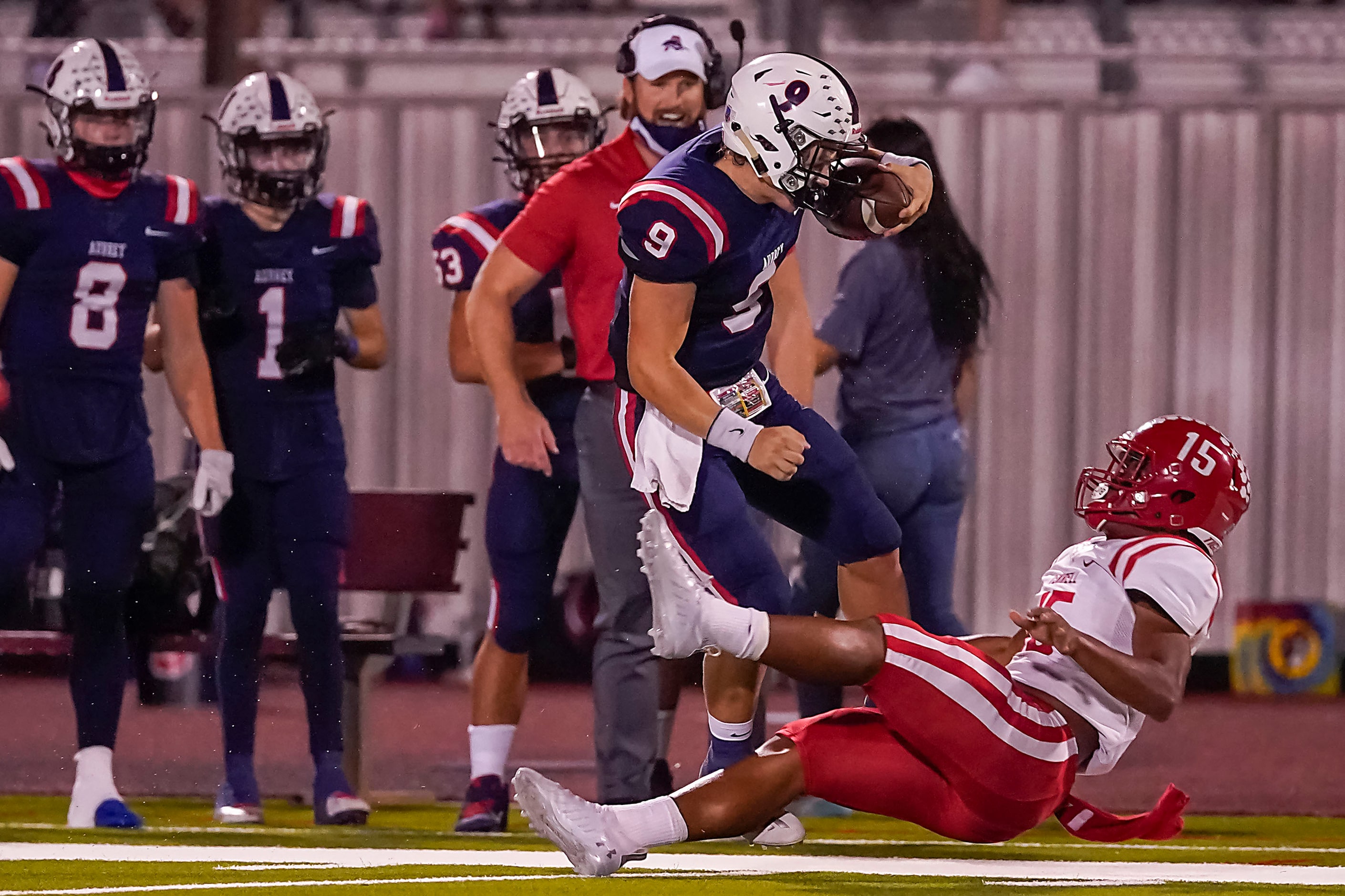 Aubrey quarterback Jaxon Holder (9) knocks over Terrell defensive backTerry Davis (15) as he...