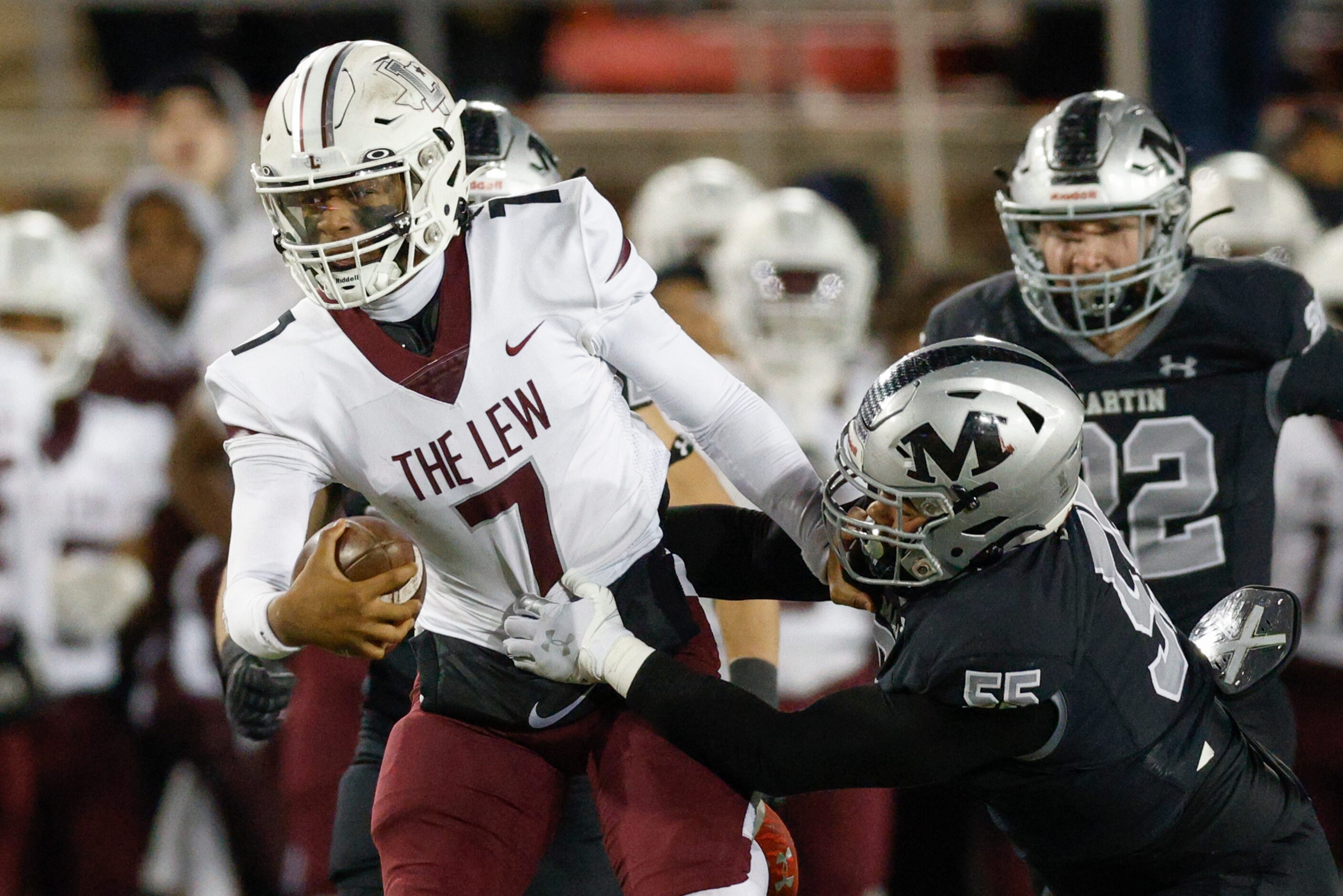 Lewisville quarterback Ethan Terrell (7) slips thorough a tackle from Arlington Martin...