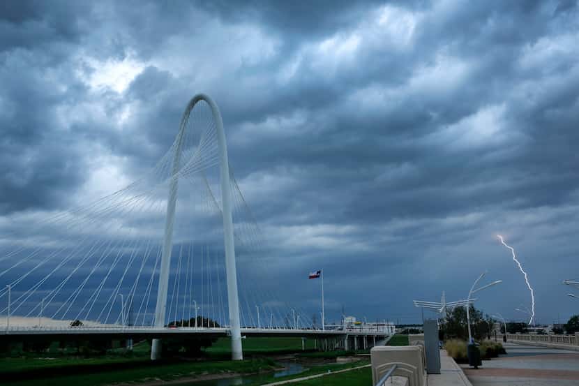 Lightning strikes in West Dallas as a thunderstorms roll past the Margaret Hunt Hill Bridge,...