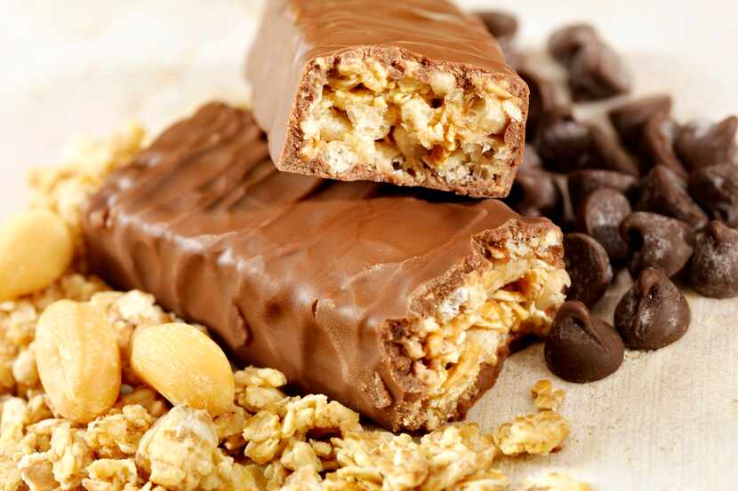 Una barra de granola y cacahuate bañada en chocolate.