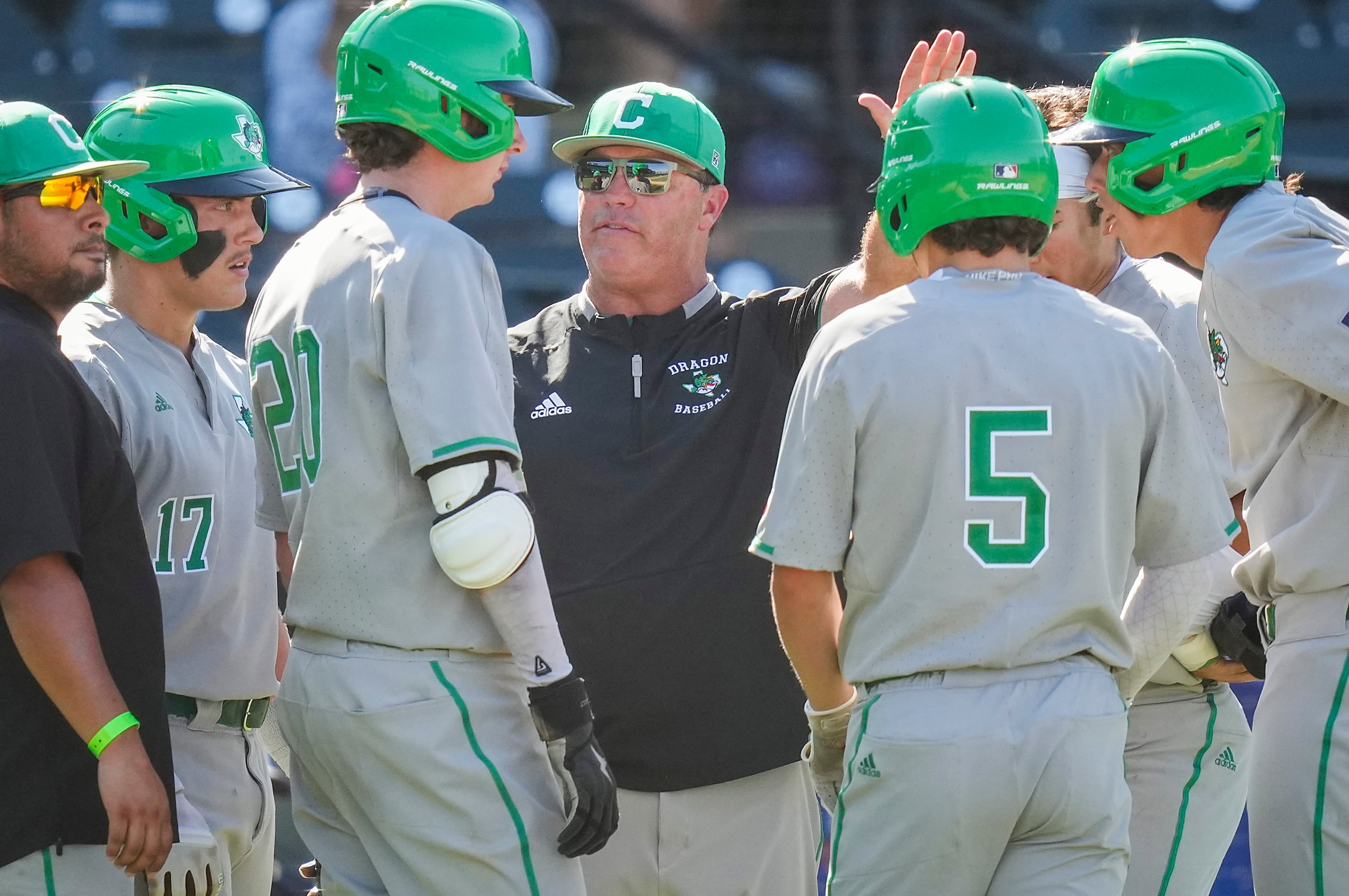 Southlake Carroll coach Larry Vucan huddles with players, including third baseman Cole...