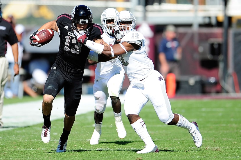 STARKVILLE, MS - NOVEMBER 03:  Mike Evans #13 of the Texas A&M Aggies stiff arms Chris...