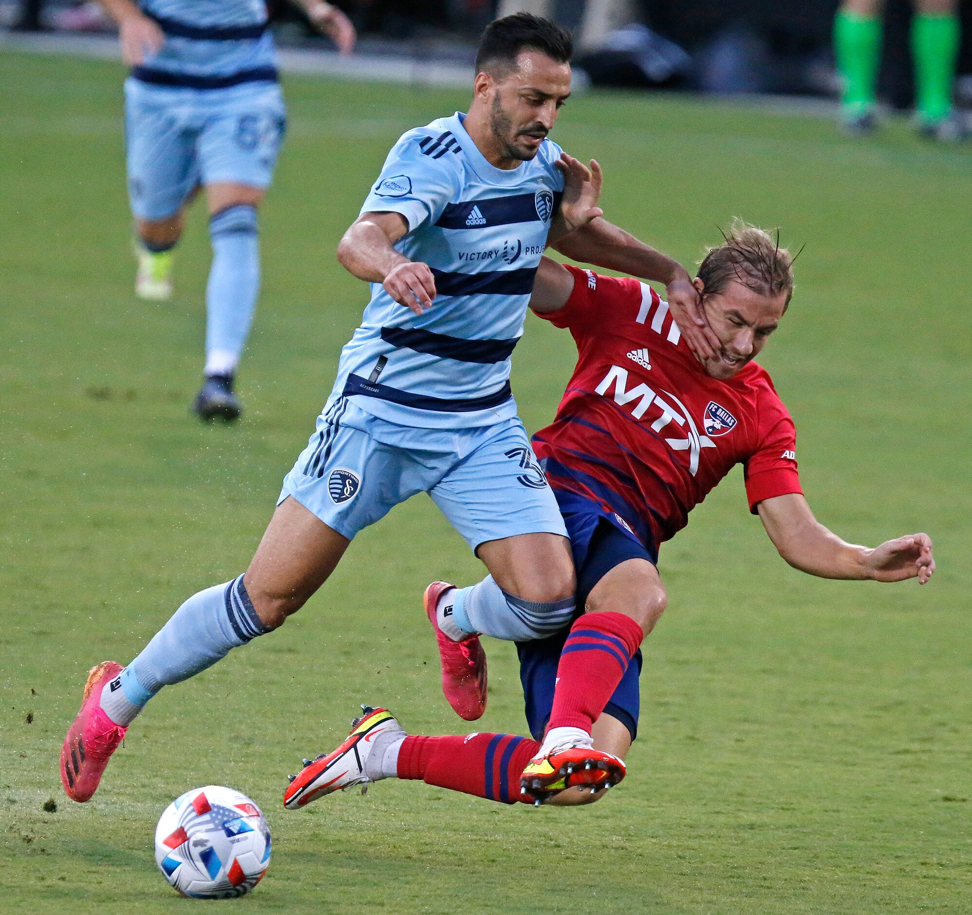 Sporting Kansas City defender Luis Martins (36) collides with FC Dallas midfielder Paxton...