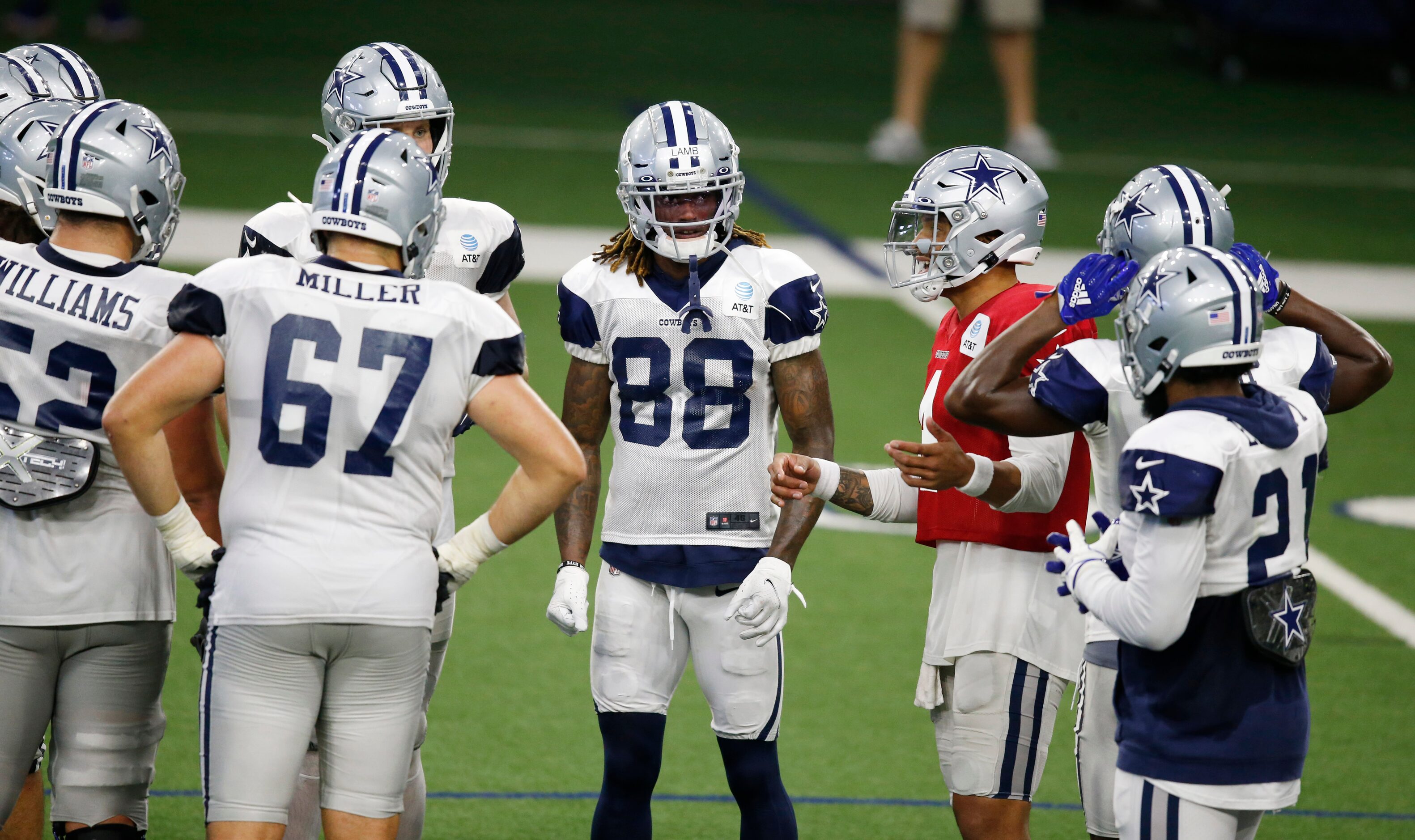 Dallas Cowboys quarterback Dak Prescott (4) talks to teammates in the huddle during training...