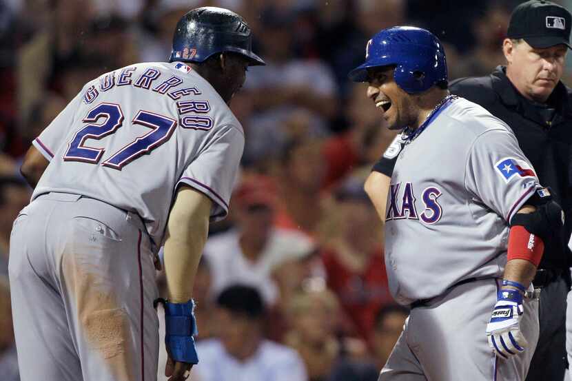 FILE - The Rangers' Bengie Molina, right, laughs with Vladimir Guerrero after crossing home...