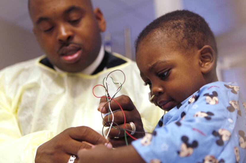 Patrick Jones adjusts medical equipment for his son Sawyer. The toddler, who turns 2 on...