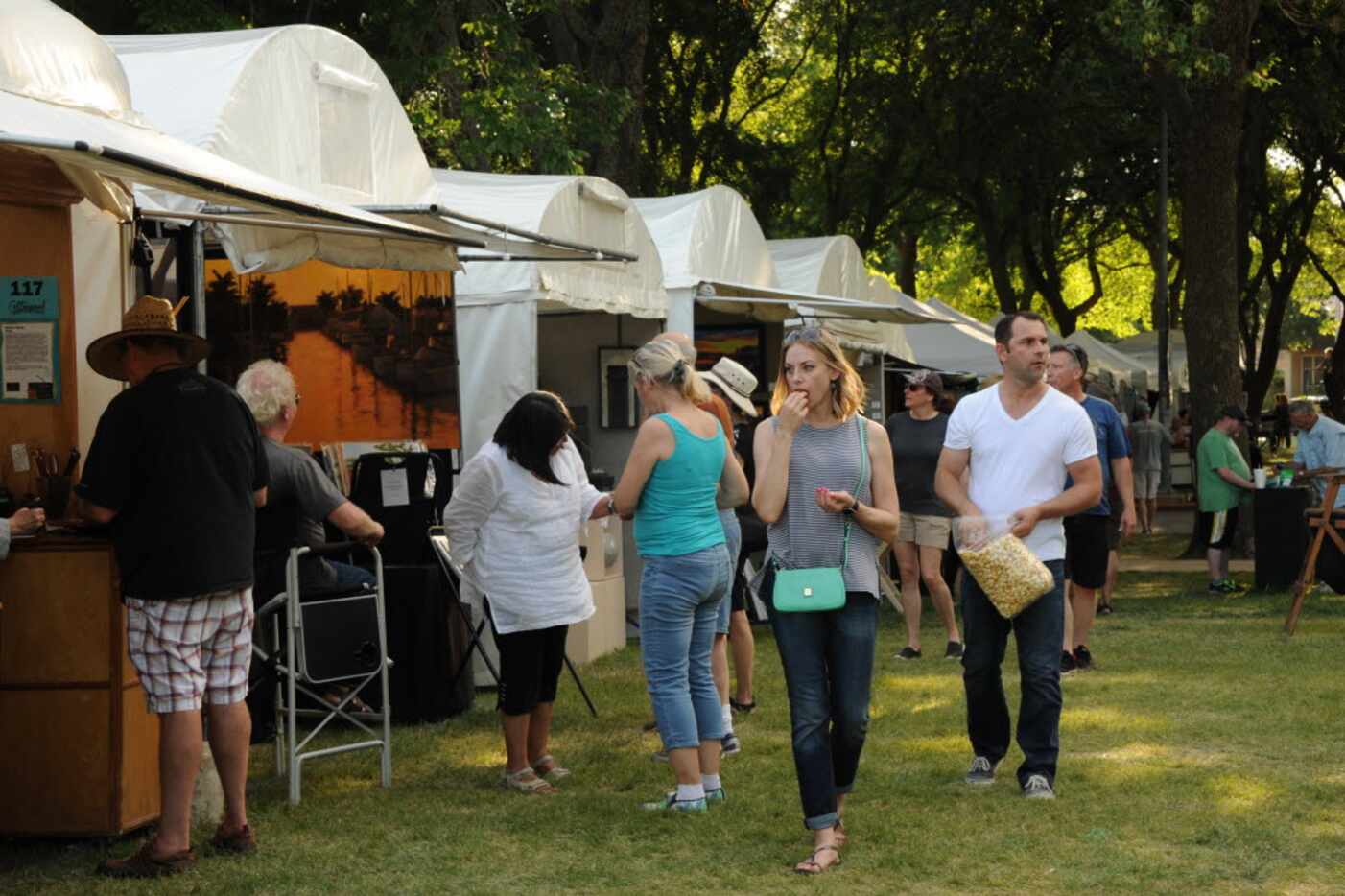 Patrons walk the festival looking at art at Cottonwood Arts Festival in Richardson, TX on...