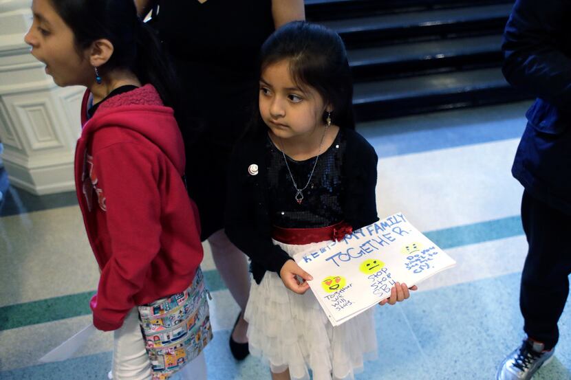 Andrea Martinez, right, and other students hand out hand-made signs and letters opposing...