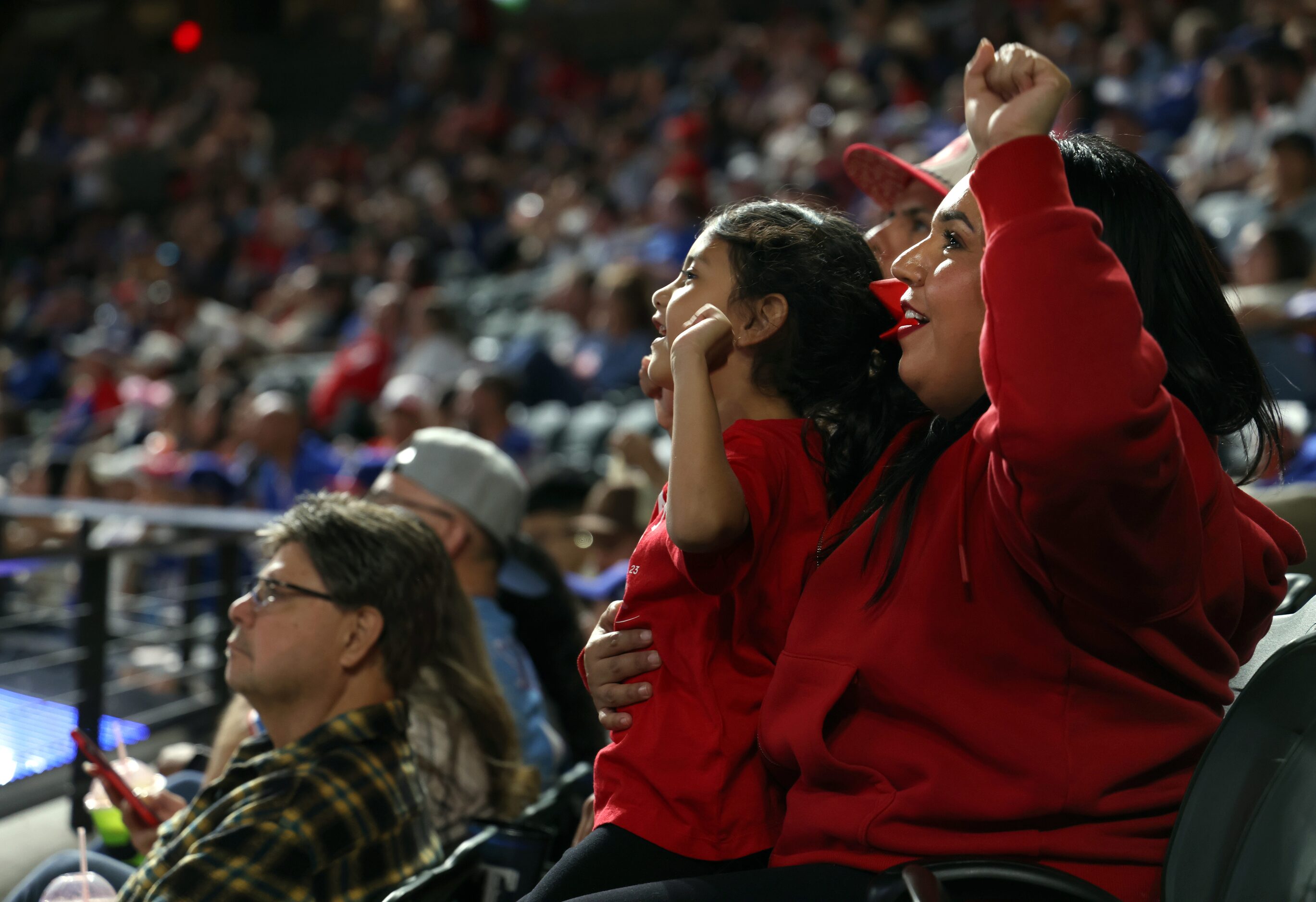 Texas Rangers fans Zamia Hernandez, right, cheers alongside her niece, Ariadne Rosales, 6,...