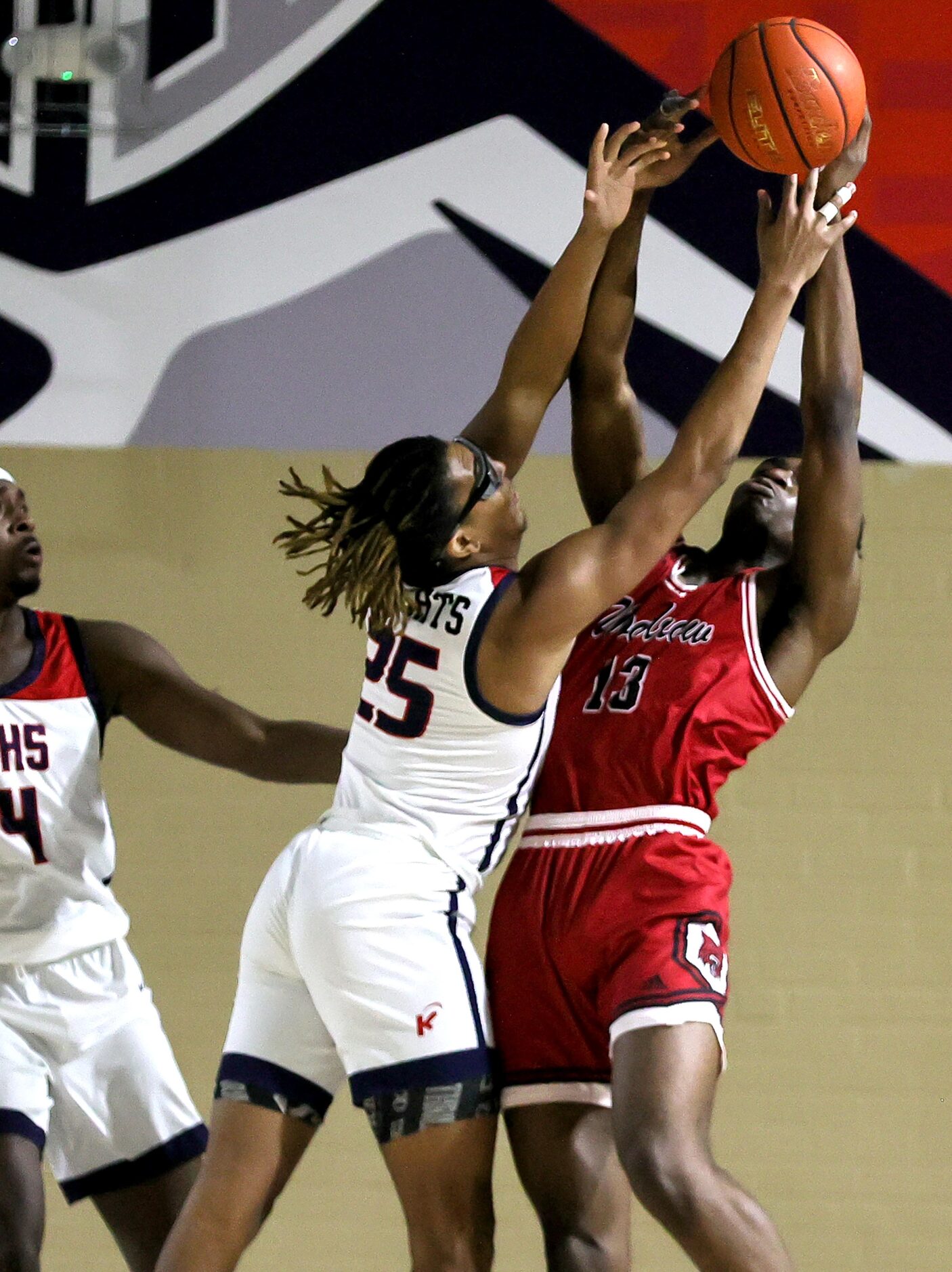 Kimball forward Tra'von Rhinehart (25) and Woodrow Wilson forward Isaac Onuoha (13) go for a...