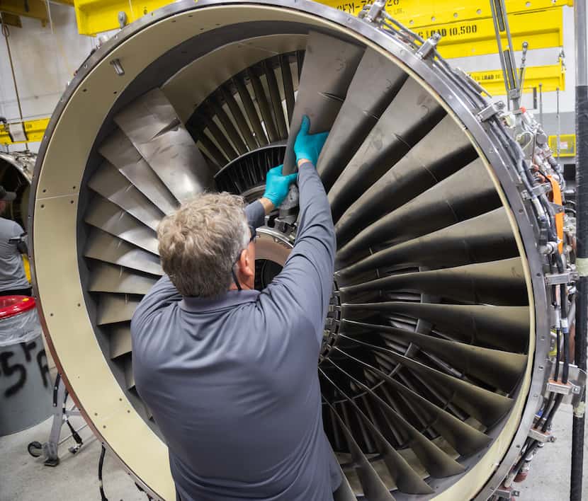 Aircraft maintenance technician Richard Hurtz adds fan blades to an engine at the American...