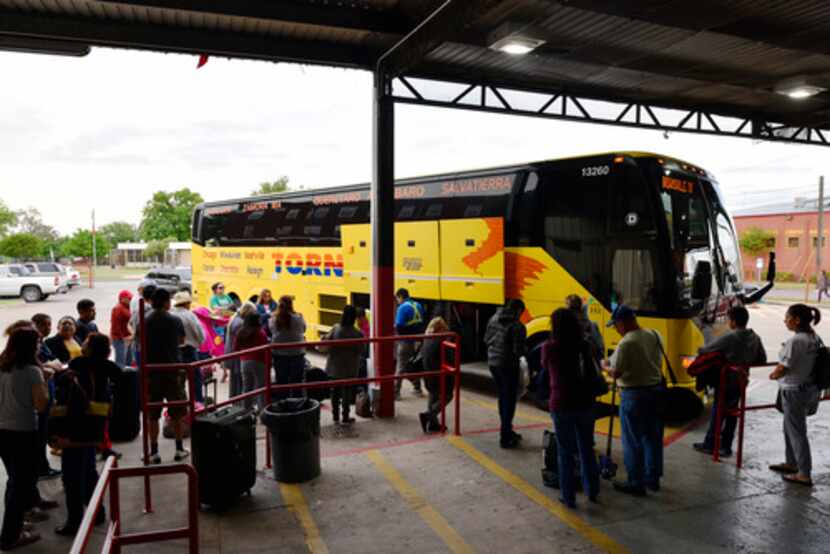 Los hispanos hacen fila para abordar un autobús que se dirige a México desde Dallas, la...