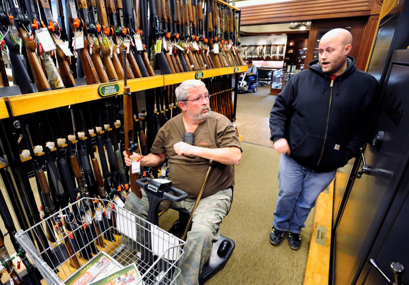 In this Nov. 10, 2014, file photo, Jerry Lyons, left, talks with Pat Ison at the Cabela's...