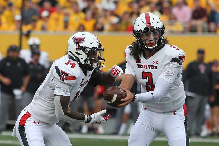 Texas Tech quarterback Henry Colombi (3) hands the ball to running back Xavier White (14)...