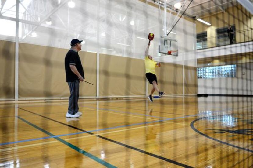 
Michael Dalby jumps to paddle the ball during a round of pickleball, while teammate Ronnie...