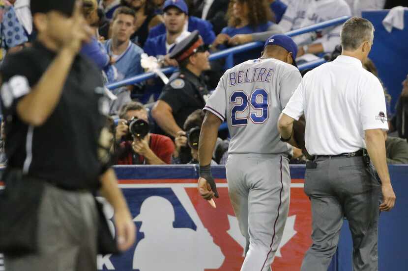 Texas Rangers third baseman Adrian Beltre (29) is helped off the field after hurting his...