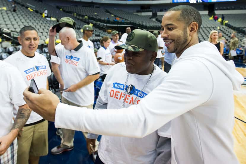 Dallas Mavericks guard Devin Harris (34) takes photos with wounded service members from...