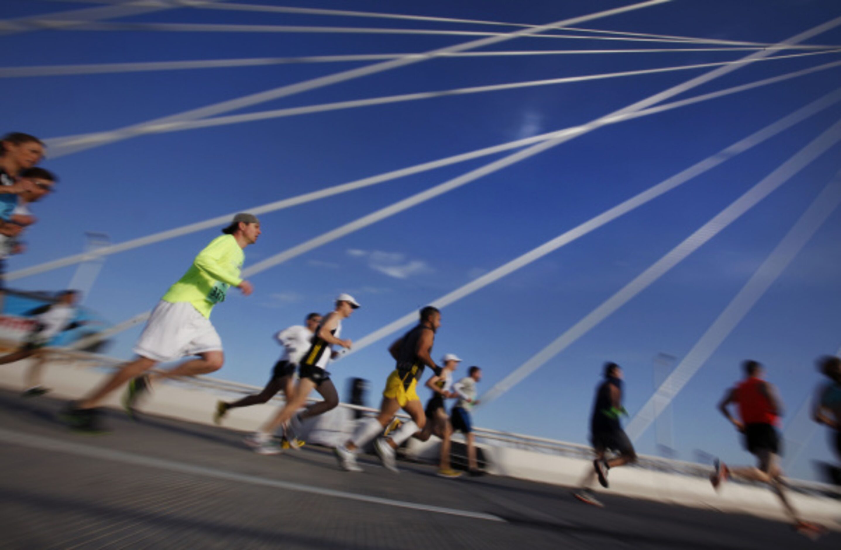 Participants run over the Margaret Hunt Hill Bridge in Dallas, TX during Trinity Sprint...