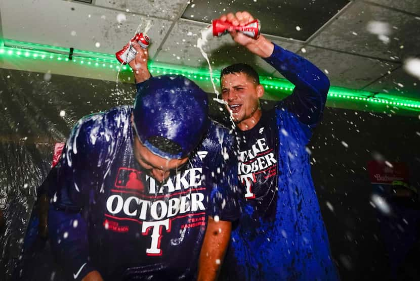 Texas Rangers second baseman Marcus Semien, left, has beer poured on him by shortstop Corey...