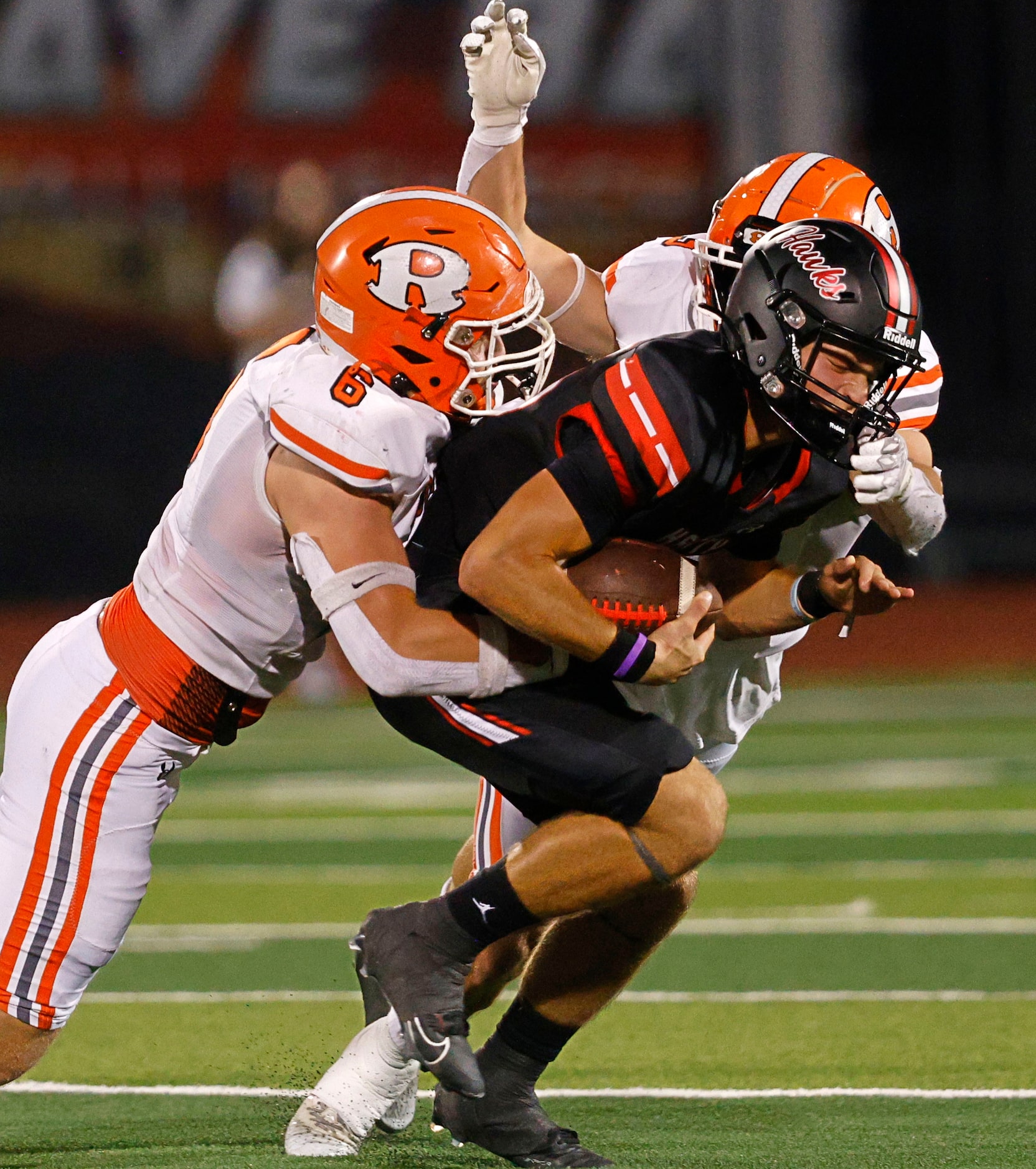 Rockwall-Heath's quarterback Landon Dutka (15) is tackled by Rockwall's Hayden Curry (6) and...