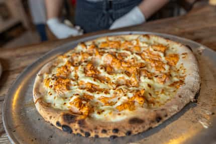 Seasoned chicken with Brazilian style catupiry cheese pizza sits fresh out of the wood-fired...